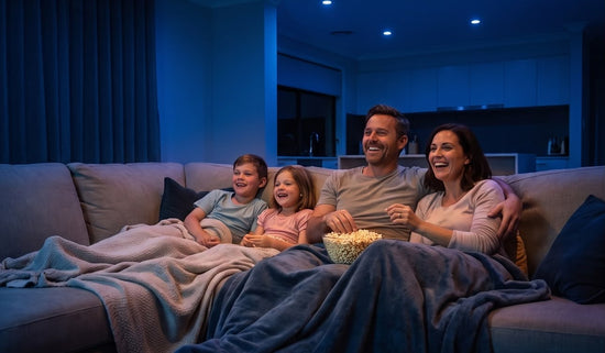 Family on the couch under blue smart downlights in movie mode
